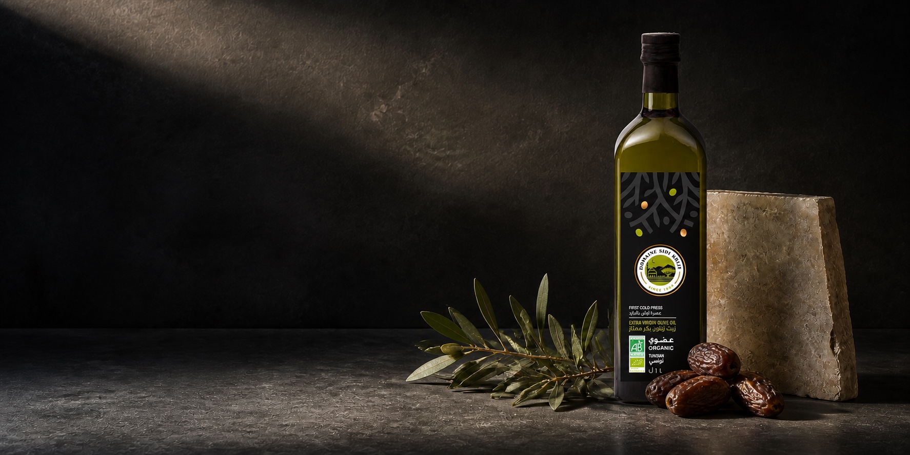 Domaine Sidi Khlif organic extra virgin olive oil, with an olive branch, Tunisian dates and a block of cut stone